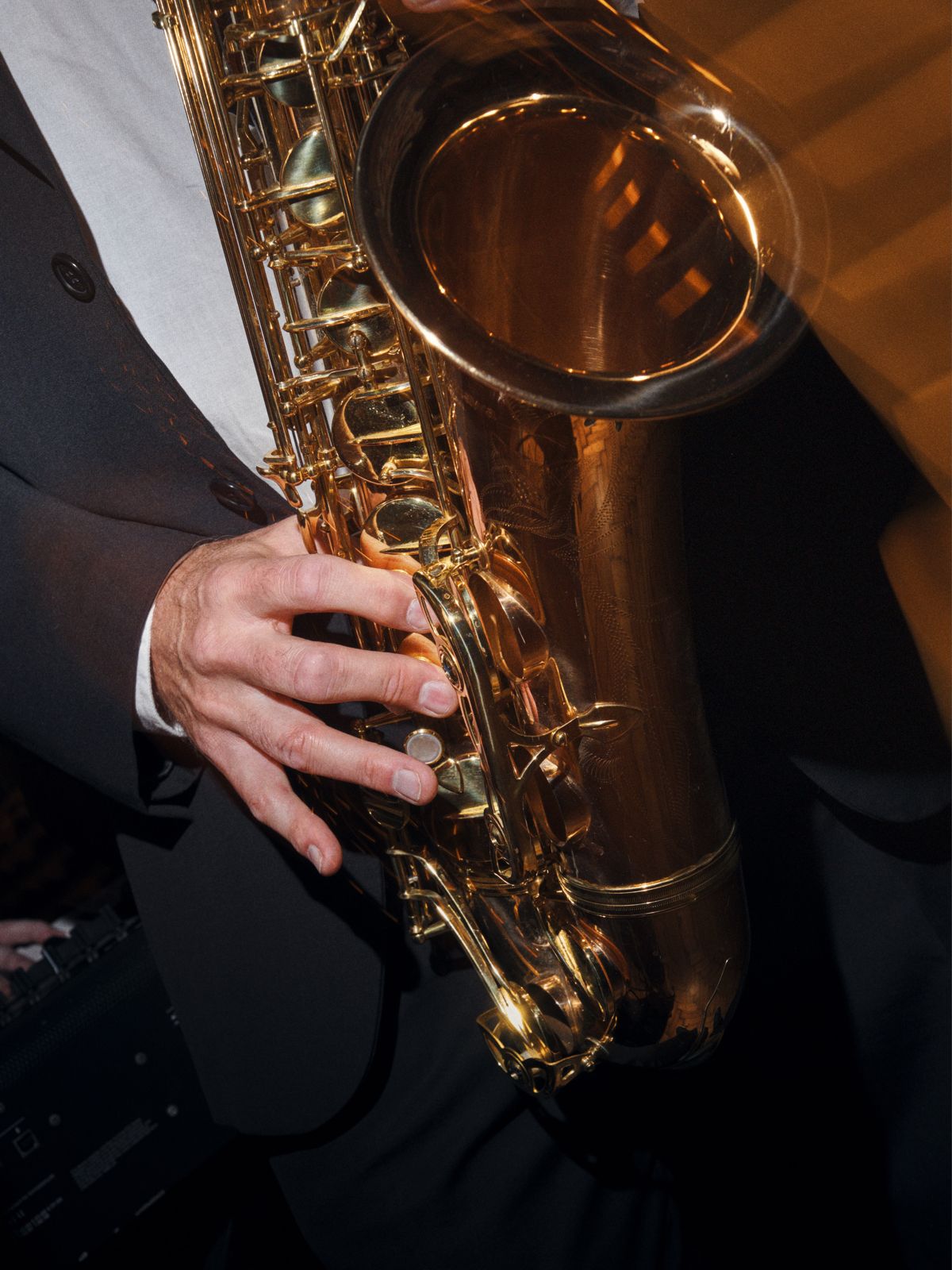 A saxophonist beneath the rock and roll portraits